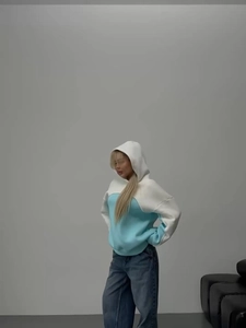 Detail of color-block hooded sweatshirt showing blue and white stitching texture