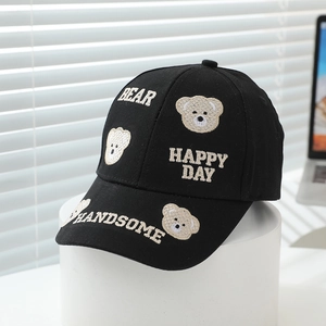 Detailed view of kids bear embroidery on black cotton baseball cap with happy text