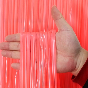 Detail of coral pink tinsel fringe curtain showing its glossy texture and translucency