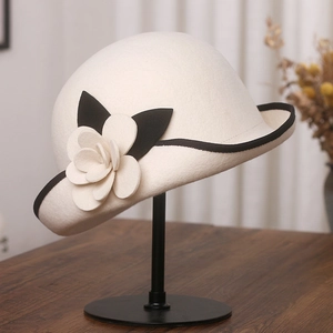 Detail of a vintage wool felt cloche hat with camellia flower and black contrast trim