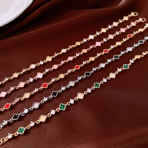 Dettaglio di cinque bracciali a quadrifoglio multicolore con zirconi su velluto
