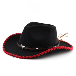 Detail of black wool felt cowboy hat with red wavy trim and silver bull skull ornament