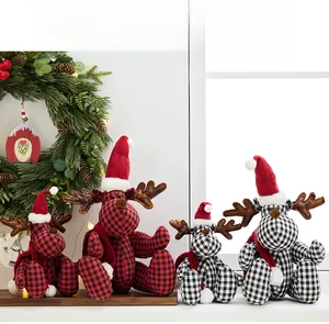 Detailed view of red and black plaid Christmas deer plush toys in a cozy window setting