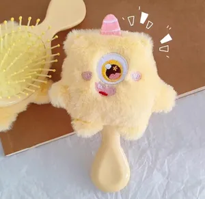 Macro detail of plush little monster hairbrush with computer embroidery and warm yellow fur