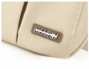 Detailed close-up of beige nylon bag material with premium leather brand logo patch