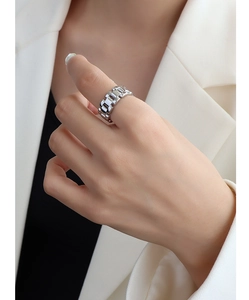 Detail of silver watch-link style ring in stainless steel worn on index finger