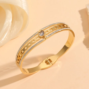 Detail of gold titanium steel bangle featuring heart-shaped zircon and pave crystals