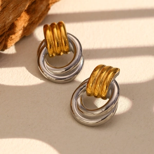 Detail of twisted interlocking circles earrings in gold and silver polished steel