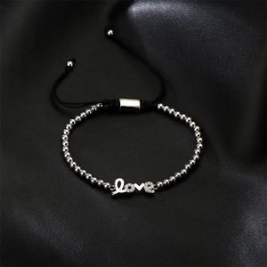 Close-up of adjustable woven bracelet featuring silver Love letter pendant with pavé zircons