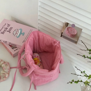 Close-up of pink quilted tote bag with soft pleated texture in a lifestyle setting