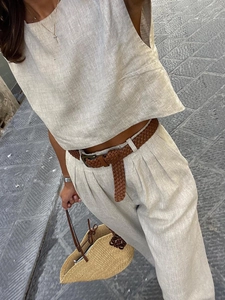 Detail eines minimalistischen beigen Leinen-Zweiteilers mit ärmellosem Oberteil und Hose