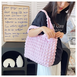 Detailed macro view of the pink bubble-textured fabric on a pleated tote shoulder bag