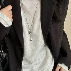 Minimalist silver star pendant necklace shown worn on grey blazer for a modern look