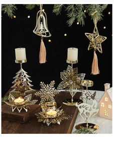 Détail d'un ensemble de bougeoirs de Noël dorés avec motifs de cerf et de flocons
