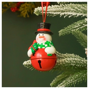 Detail of Christmas snowman ornament with red metal bell hanging on a snowy tree branch