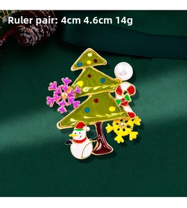 Detailed view of Christmas tree brooch with enamel finish and pearl on a festive background