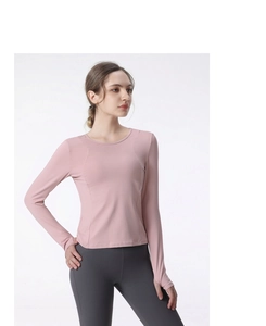 Detail of long sleeve yoga top featuring functional thumbholes and pink athletic fabric