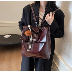 Dettaglio dello zaino vintage in pelle oliata rosso scuro con ciondolo e chiusura in metallo