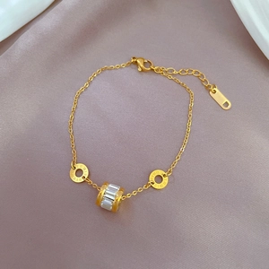 Détail du bracelet doré avec chiffres romains et perles de zircon sur soie