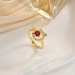 Detailed shot of gold celestial ring with red center stone on white ceramic tray