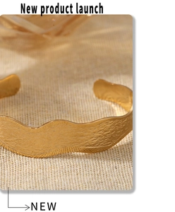 Macro shot of 18K gold plated wavy texture bangle with polished hammer finish detail