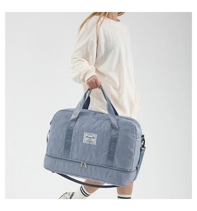 Detail of light blue quilted travel bag with star pattern and separate shoe compartment