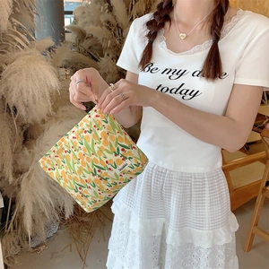 Detail of canvas tulip makeup bag with yellow floral pattern and Sozakka side label