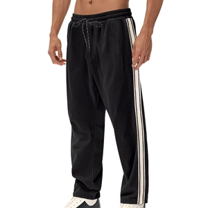 Detailed view of black corduroy trousers with side stripes and elastic drawstring waist