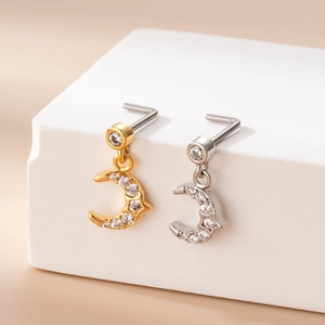 Detailed view of silver and gold crescent moon nose studs with pave cubic zirconia