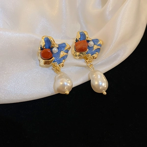 French vintage earrings with blue enamel, orange stones and baroque pearls on white silk