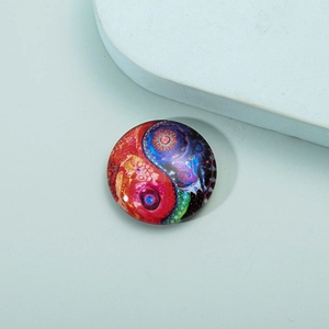 Macro view of crystal glass fridge magnet featuring a vibrant mandala yin yang design
