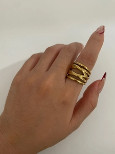 Detail shot of wide gold crisscross ring with textured layers shown on a model hand