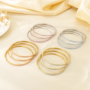 Close-up of colorful enamel layered bangles in gold and silver stainless steel finish