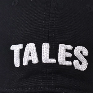 Black cotton baseball cap with white TALES 3D embroidery and textured twill fabric
