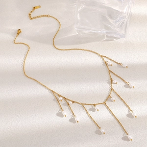 Détail du collier en acier inoxydable plaqué or 18K avec élégants pompons en perles