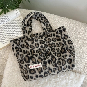 Detail of plush leopard print tote bag with soft texture and white brand label