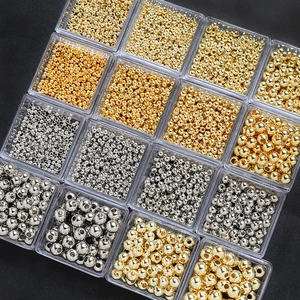 Detalle macro de cuentas de cobre oro y plata en una caja de 16 compartimentos