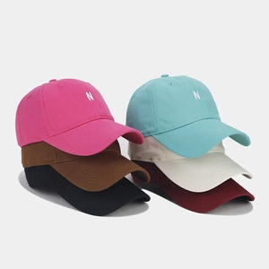 Close-up of baseball caps in various colors with white N letter embroidery on cotton twill