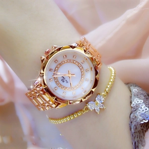 Close-up of rose gold women's watch with flower mother-of-pearl dial and rhinestones