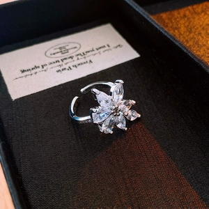 Detail view of flower-shaped ring with marquise-cut stones and crystal-set silver band
