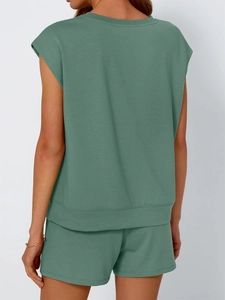 Back view of woman in sage green sleeveless top and shorts lounge set on white background