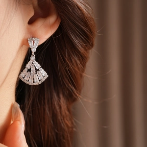 Detailed view of elegant fan-shaped zircon earrings worn on a model for a luxury look