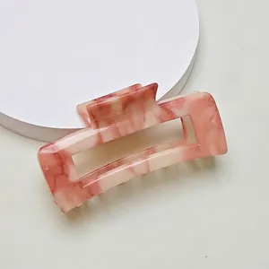 Macro view of rectangular pink marble texture hair claw clip with non-slip teeth