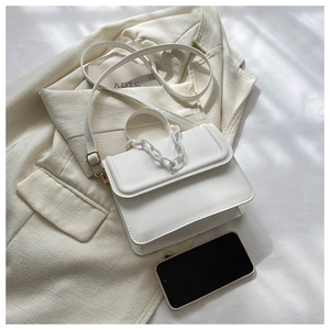 Close-up of white PU leather flap bag with decorative thick chain and strap