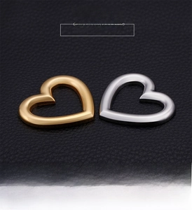 Detailed view of heart-shaped hollow stainless steel pendants in gold and silver finish