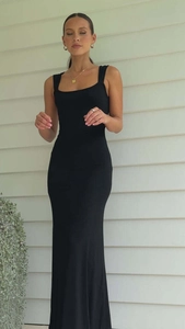 Détail de la robe mi-longue dos nu noire moulante avec larges bretelles et décolleté carré