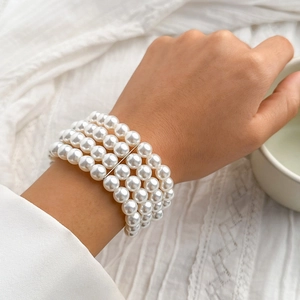 Detail of multi-strand white pearl bracelet featuring four layers and silver spacer bars