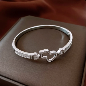 Macro view of silver heart bracelet with white zircon pavé on a leather display box