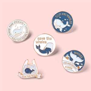 Set of 5 round enamel whale pins with Save the Ocean slogans on pink background