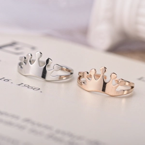 Macro shot of silver and rose gold adjustable crown rings in polished stainless steel